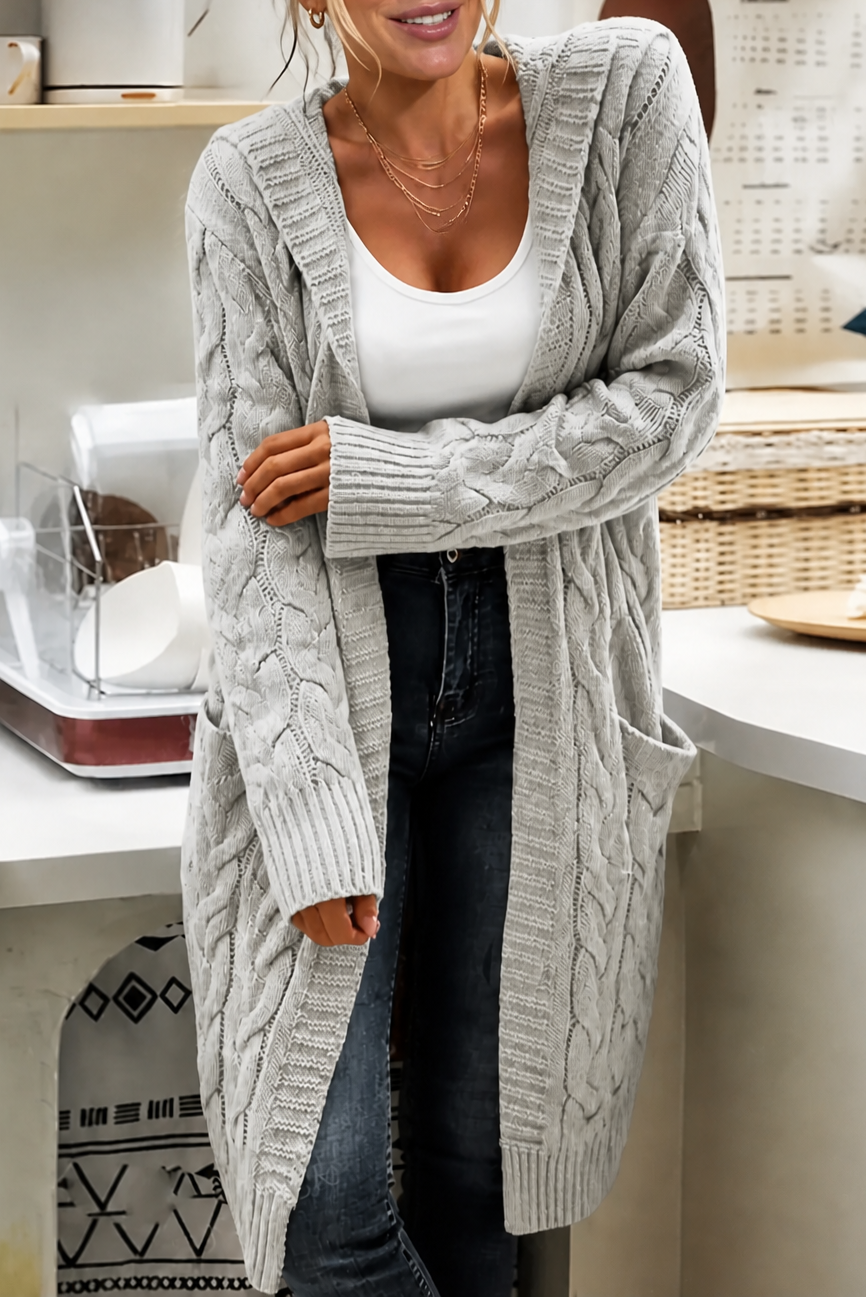 Close view of the cream hooded cardigan’s textured front, ribbed opening, long sleeve cuff, and side patch pocket.