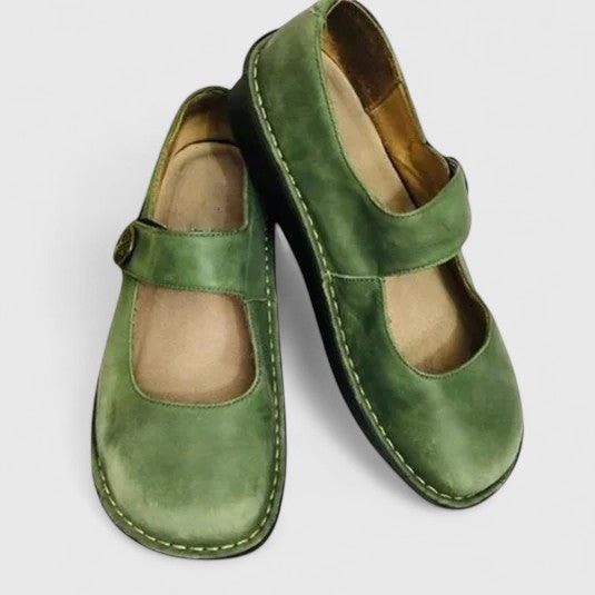 Green Mary Jane flats shown at an angled view, with rounded toes, adjustable instep straps, and contrasting stitching around the soles.