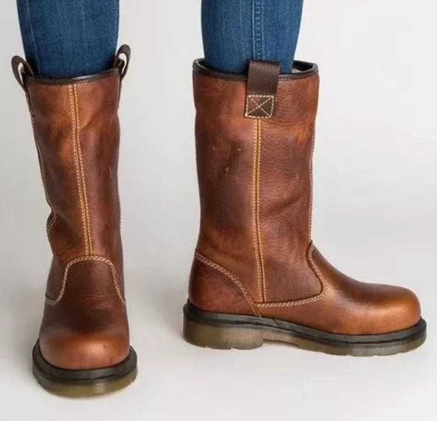Pair of brown mid-calf pull-on boots with round toes, rear tabs, contrast stitching, low block heels, and treaded soles, shown from the front and side.