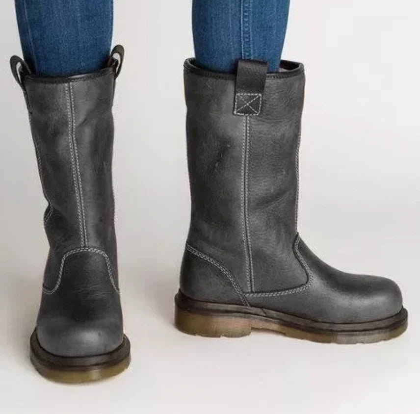 Pair of dark gray mid-calf pull-on boots with round toes, contrasting stitching, rear tabs, low block heels, and textured soles, shown in front and side views.
