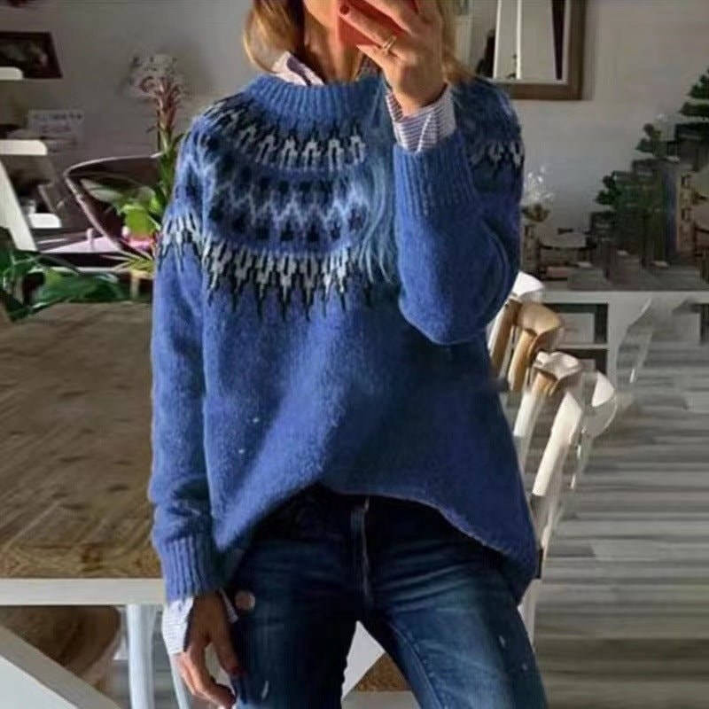 Blue crew neck Nordic-pattern sweater with a darker patterned yoke, ribbed cuffs, and a relaxed hem worn with jeans.