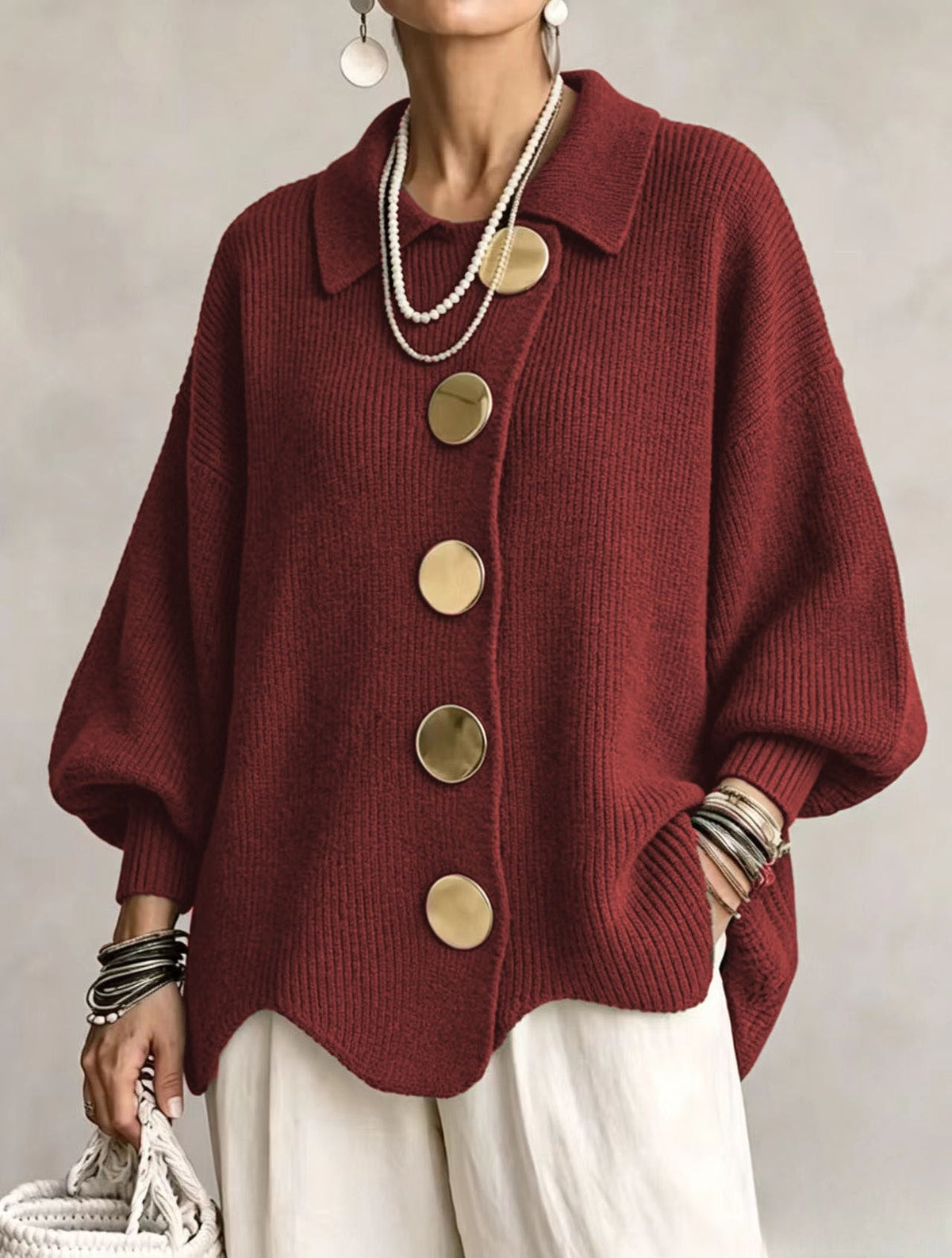Deep red oversized cardigan with five contrasting round buttons, balloon sleeves, ribbed cuffs, and a gently curved hem.