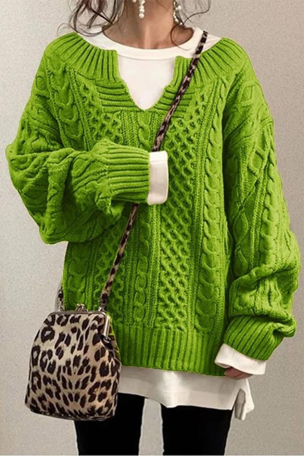 Bright green oversized cable knit sweater featuring a V-neckline, textured vertical cables, and dropped sleeves.