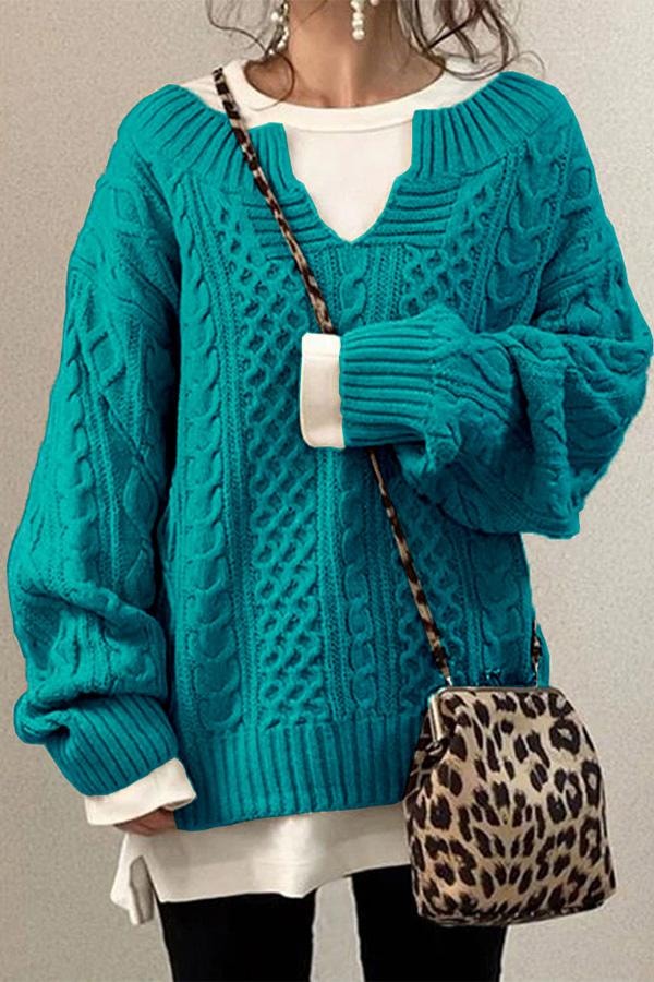 Turquoise oversized V-neck sweater with intricate cable knit panels, voluminous sleeves, and a ribbed hem.