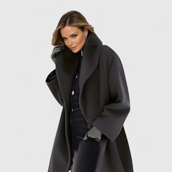 Black oversized coat with broad lapels, long sleeves, and a mid-thigh silhouette.