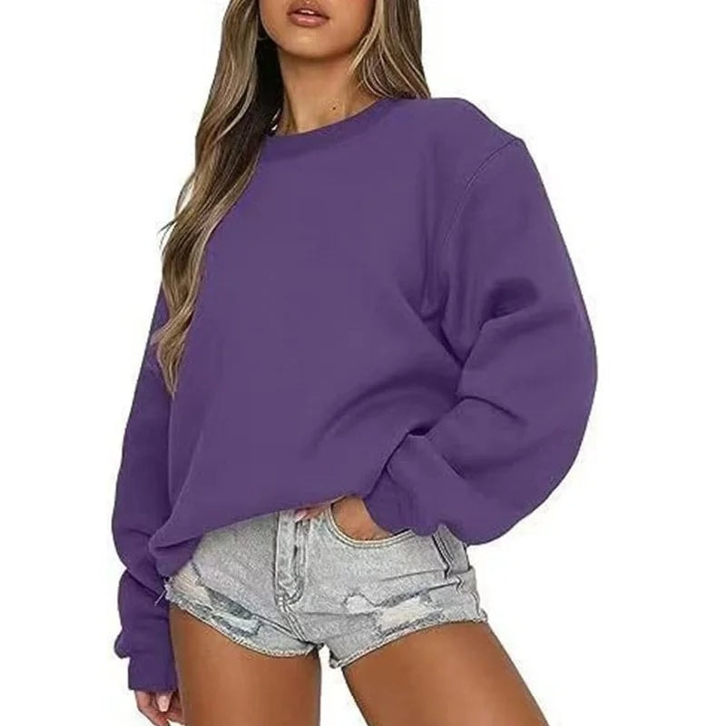 Purple oversized crew neck sweatshirt on a model, highlighting the relaxed fit and ribbed cuffs at the wrists.