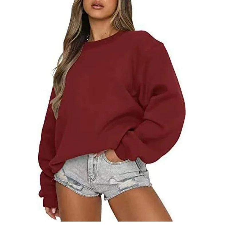 Deep burgundy oversized sweatshirt on a model, showing the relaxed crew-neck shape and long gathered sleeves.