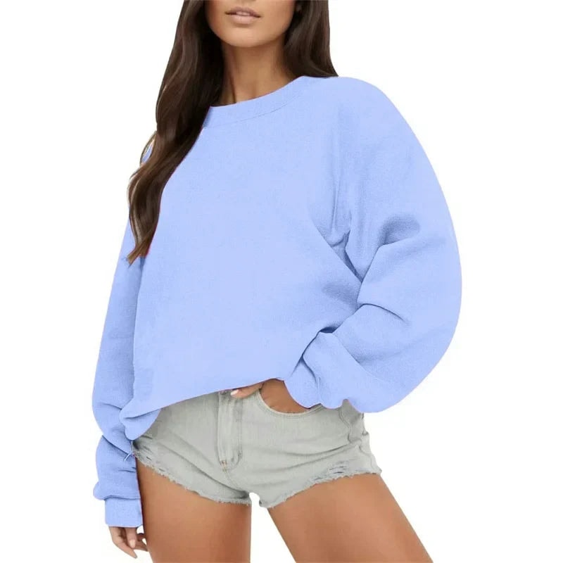 Model wearing the oversized sweatshirt in light blue with a classic crew neckline and relaxed balloon-shaped sleeves.