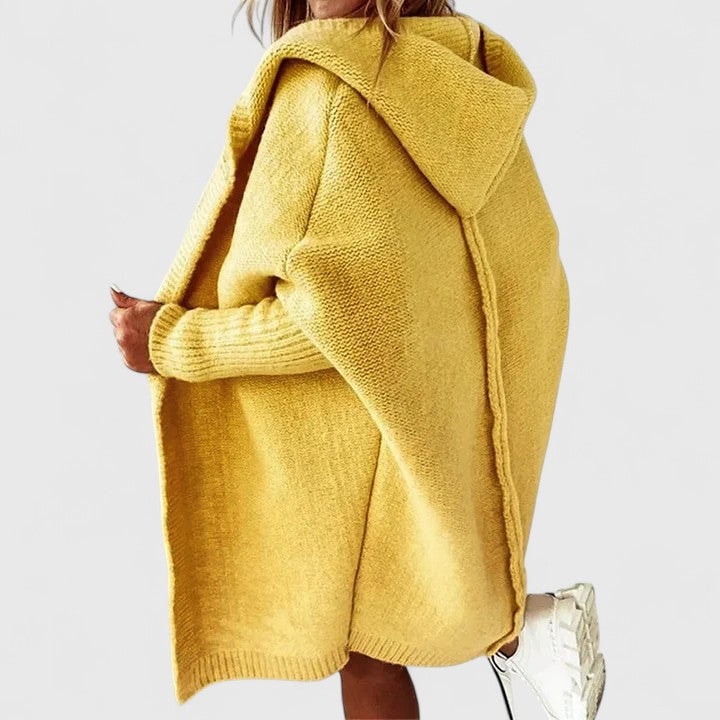 Mustard-yellow oversized cardigan shown in side view, highlighting the generous hood, draped open front, and longer silhouette.