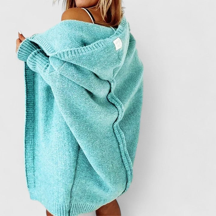 Turquoise hooded cardigan viewed from the back at a slight angle, clearly showing the hood, relaxed drape, long coverage, and ribbed hem.