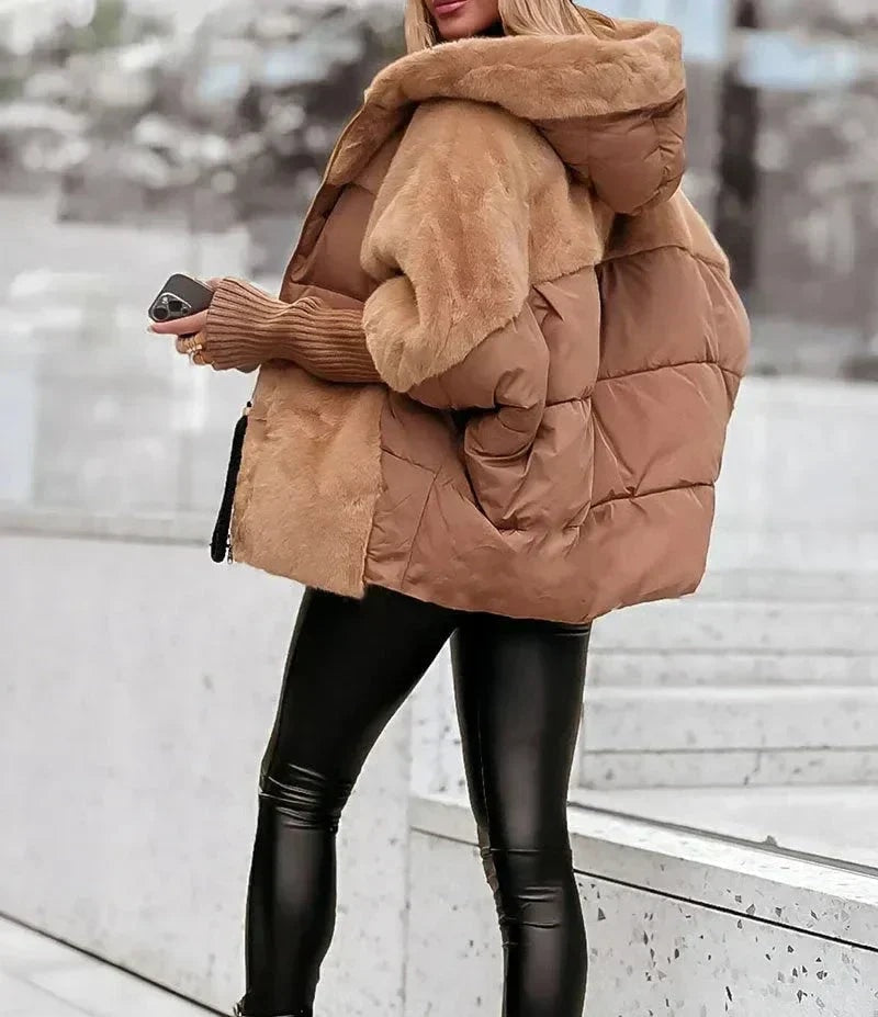Side view of the camel hooded puffer jacket highlighting its voluminous quilted body, plush sleeve panels and roomy fit.