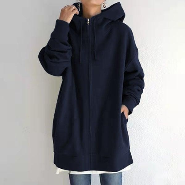 Front view of the oversized longline zip-up hoodie in navy, styled open at the neckline with one hand in a side pocket.