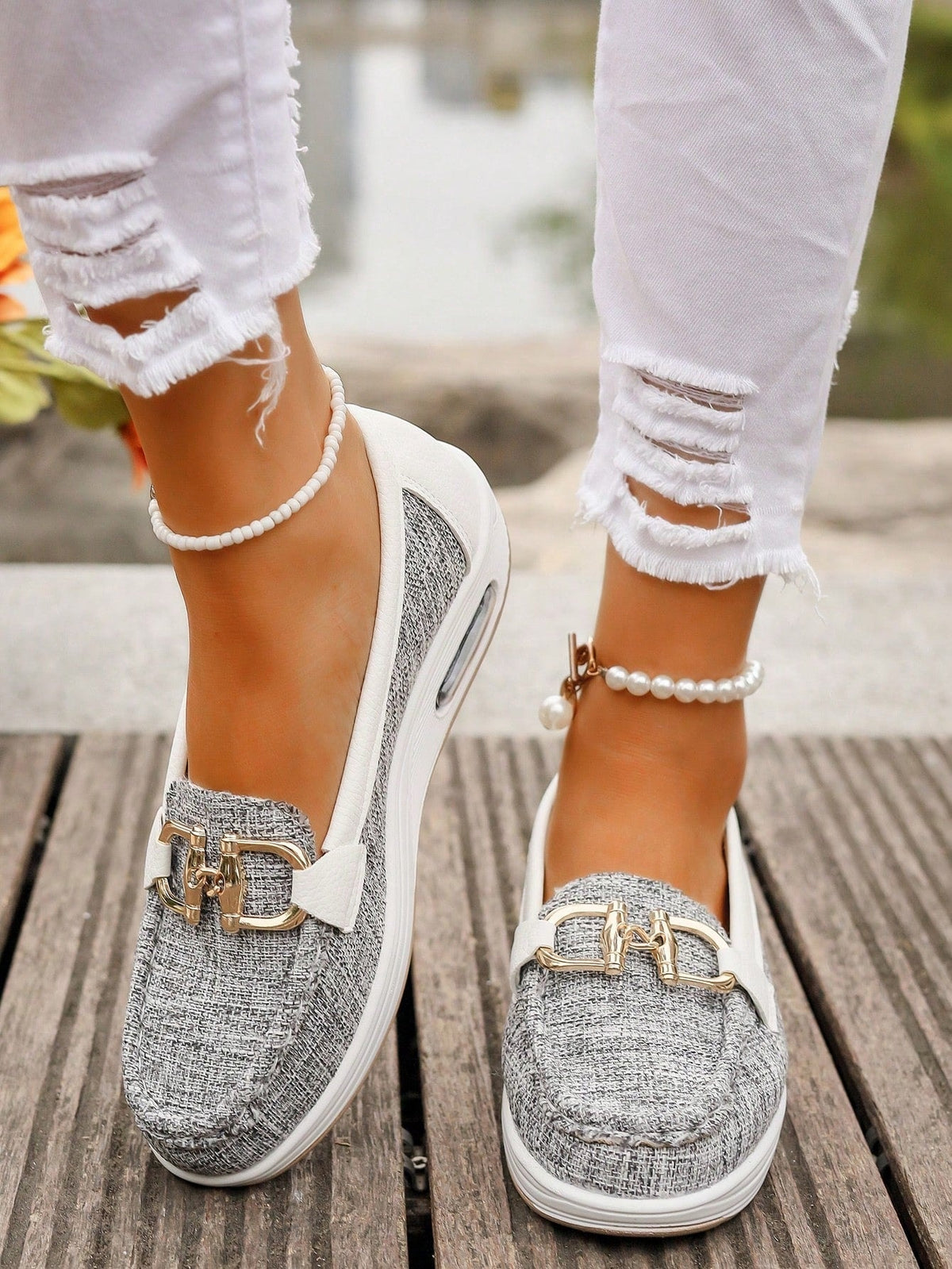 Light gray textured platform loafers with white soles, rounded stitched toes, and gold-tone buckle details shown from above.