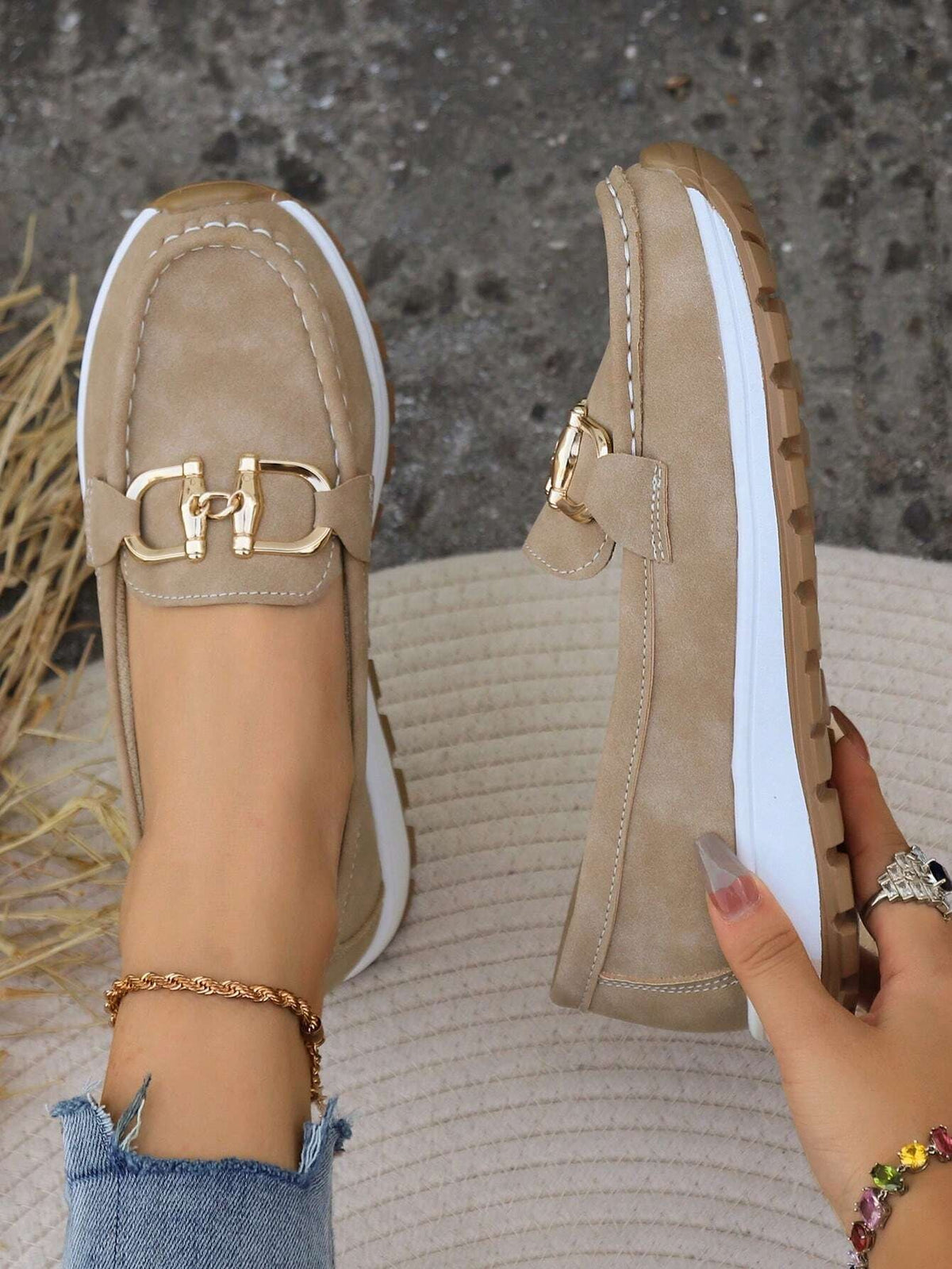 Top and side view of beige loafers displaying the rounded stitched toes, metal buckle accents, and thick platform sole.