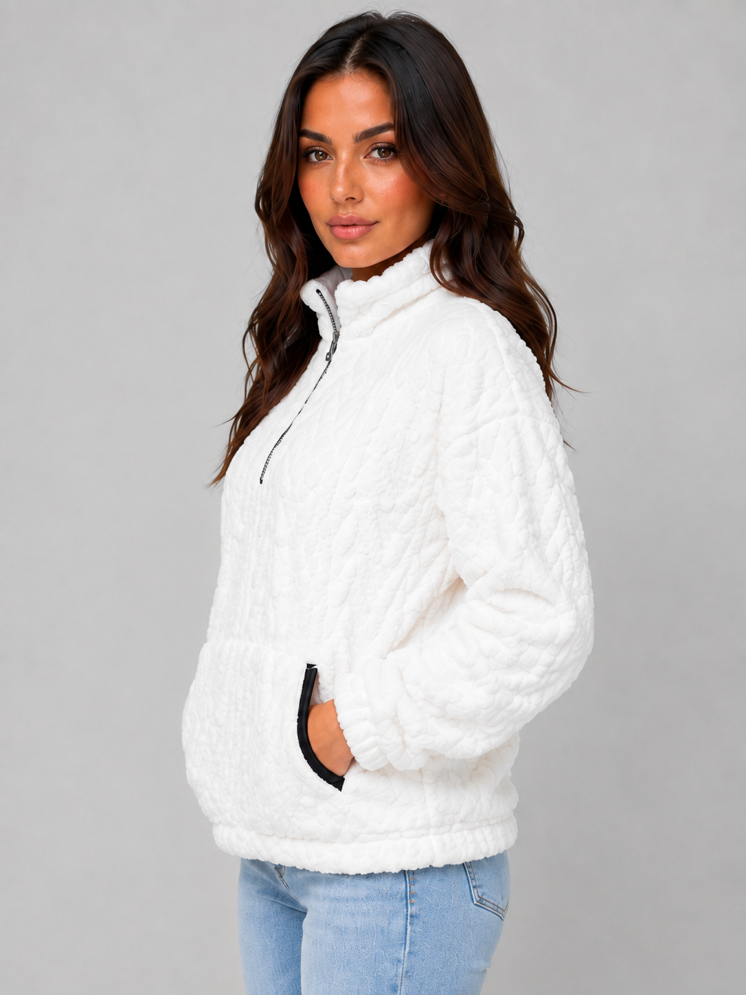 Side view of the white plush half-zip pullover highlighting the raised neckline and roomy front pocket.