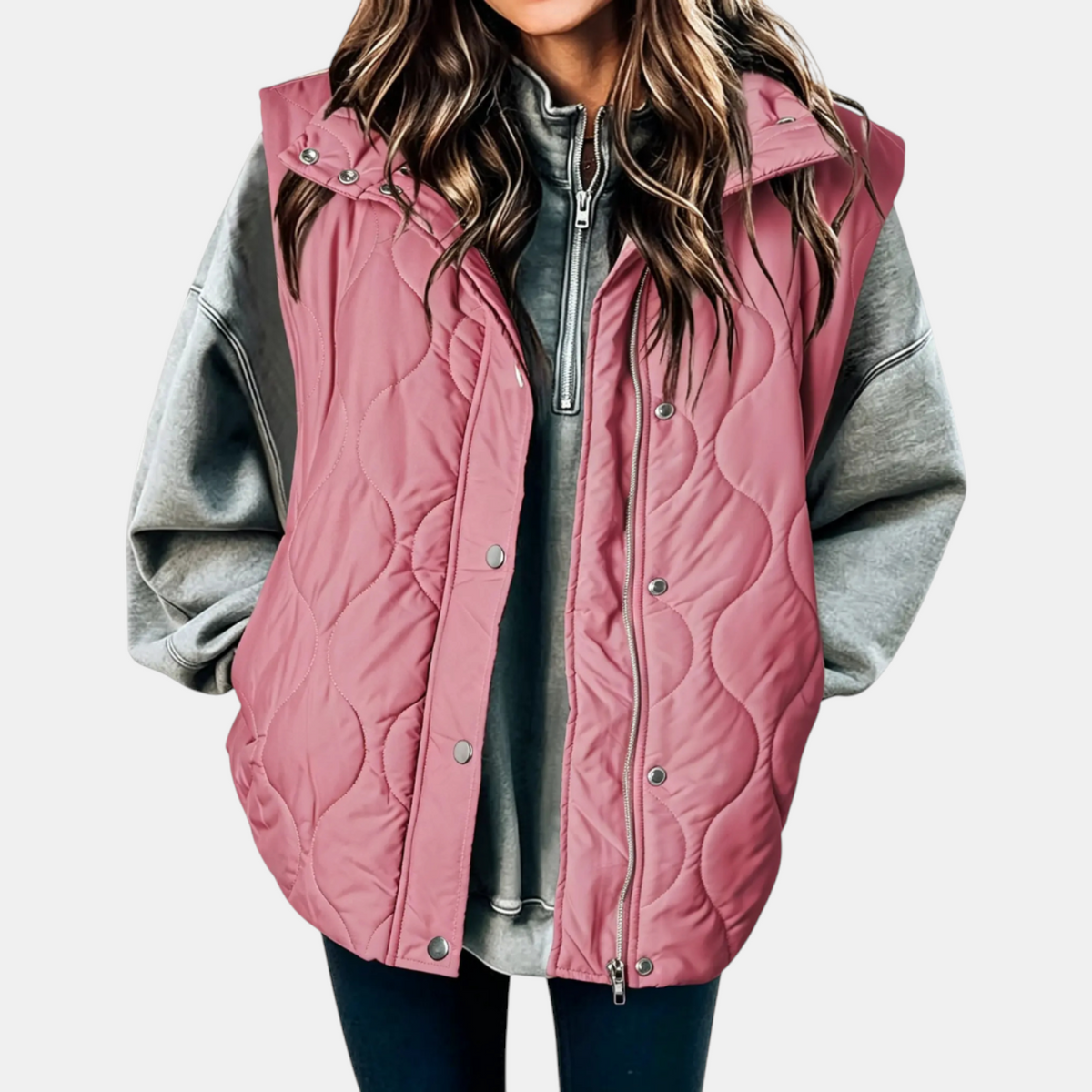 Pink longline puffer vest with a hood, wave quilted pattern, and practical side pockets.