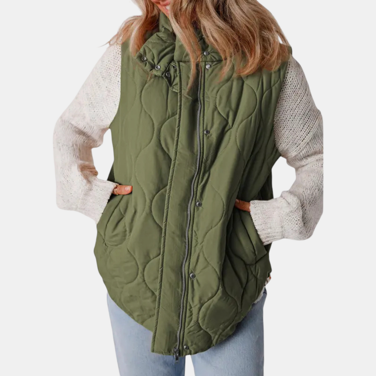 Olive quilted hooded vest shown in profile over a light knit sweater, with both hands placed in the side pockets.
