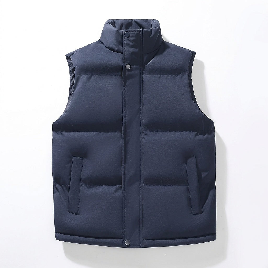 Navy puffer vest shown from the front with the raised collar, central snap closure, and two contrasting pocket openings.