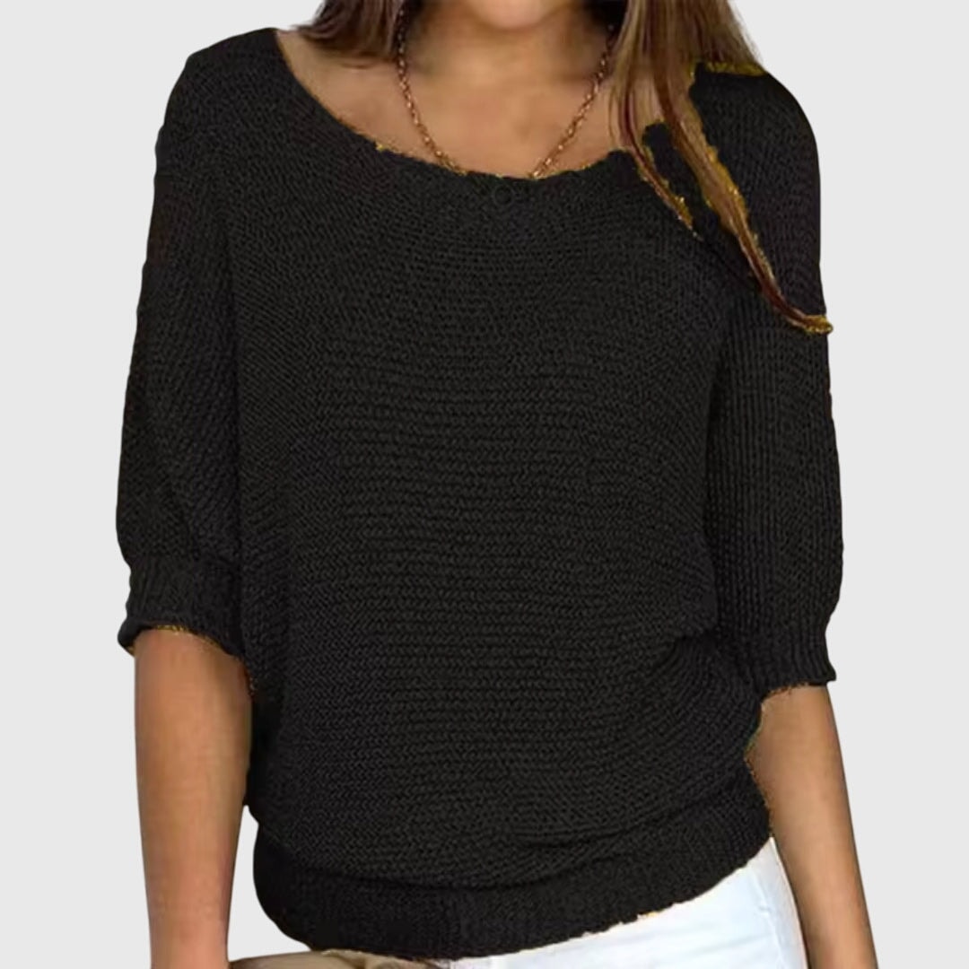 Black boat neck sweater with roomy sleeves ending in ribbed three-quarter-length cuffs.