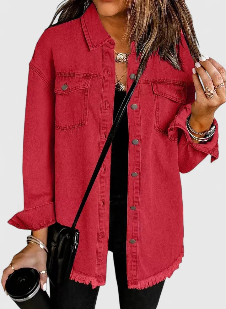 Red button-front trucker jacket layered over a black top, with a pointed collar and two buttoned chest pockets.