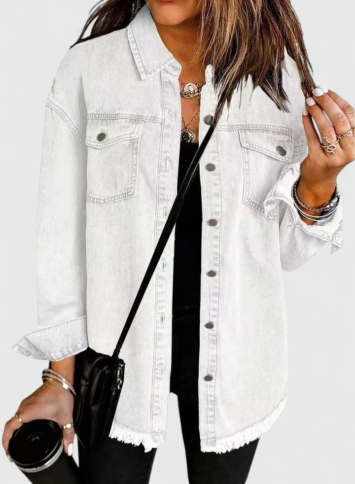 White relaxed trucker jacket with long sleeves, front buttons, chest pockets, and a visibly fringed raw hem.