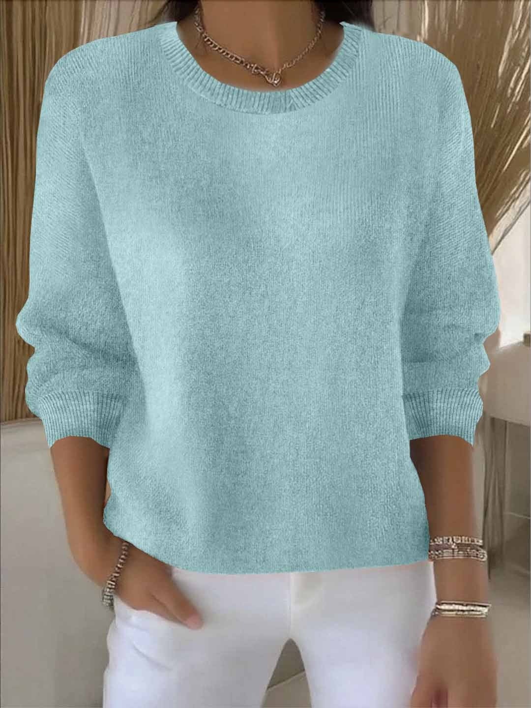 Pale aqua relaxed sweater highlighting the classic crew neckline, loose body, and ribbed sleeve cuffs.