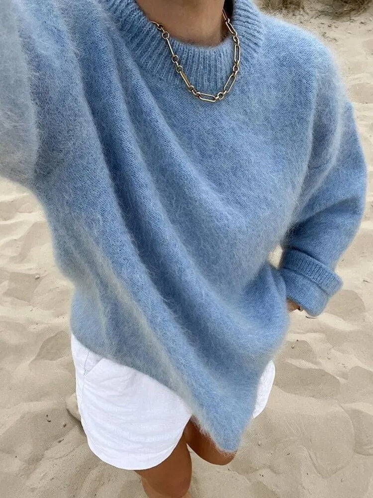 Blue crew-neck sweater paired with white shorts, showing a ribbed neckline, long sleeves, and folded cuffs.