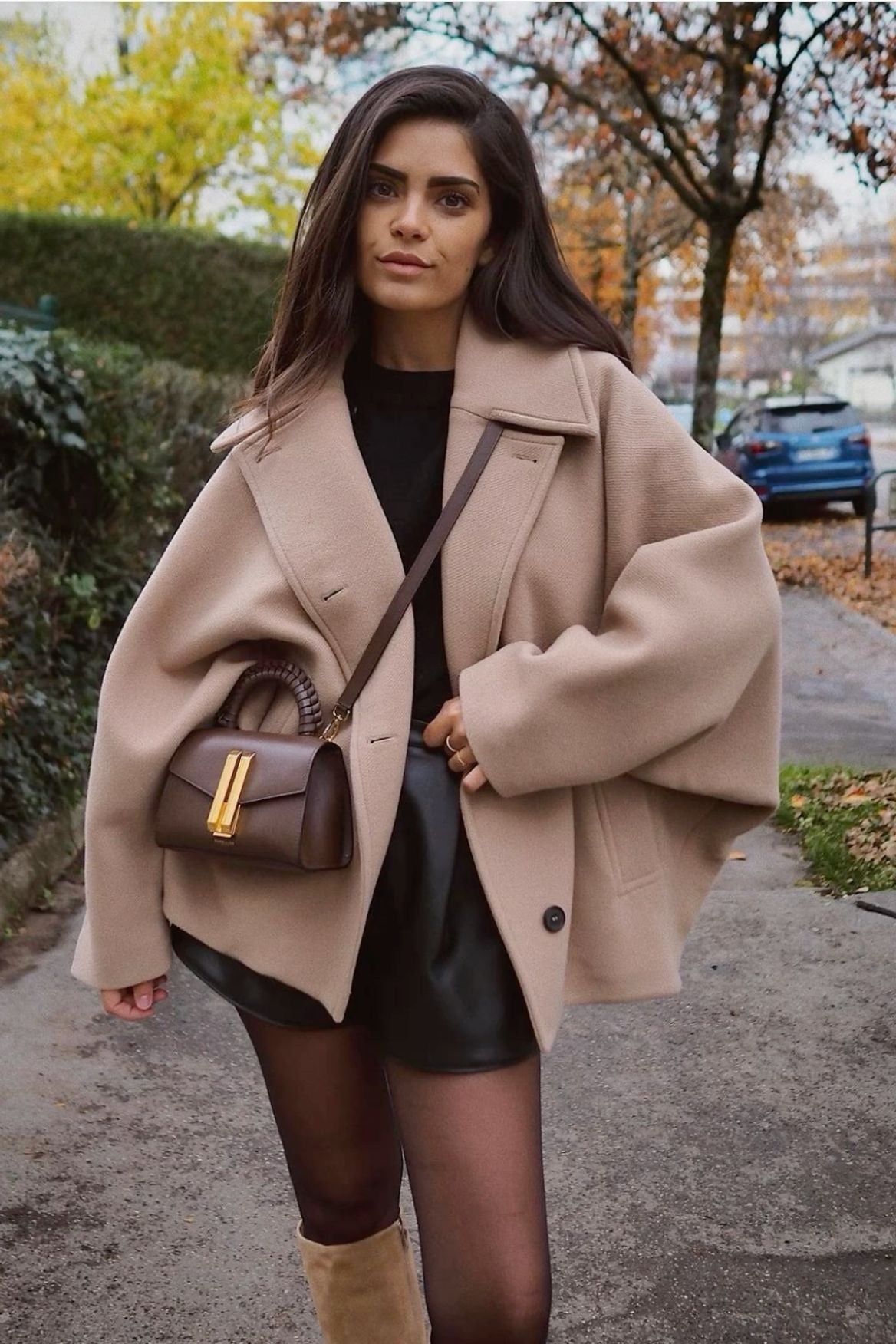 Relaxed camel short coat styled over a dark outfit, showing the wide point collar and oversized sleeves.