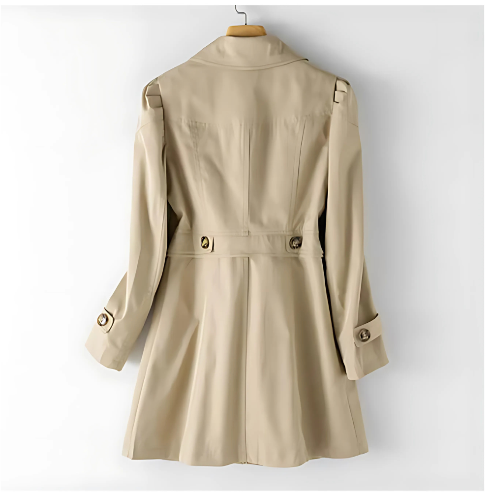 Back view of the beige mid-length trench coat, showing the waist seam, rear button details, long sleeves, and adjustable cuff straps.