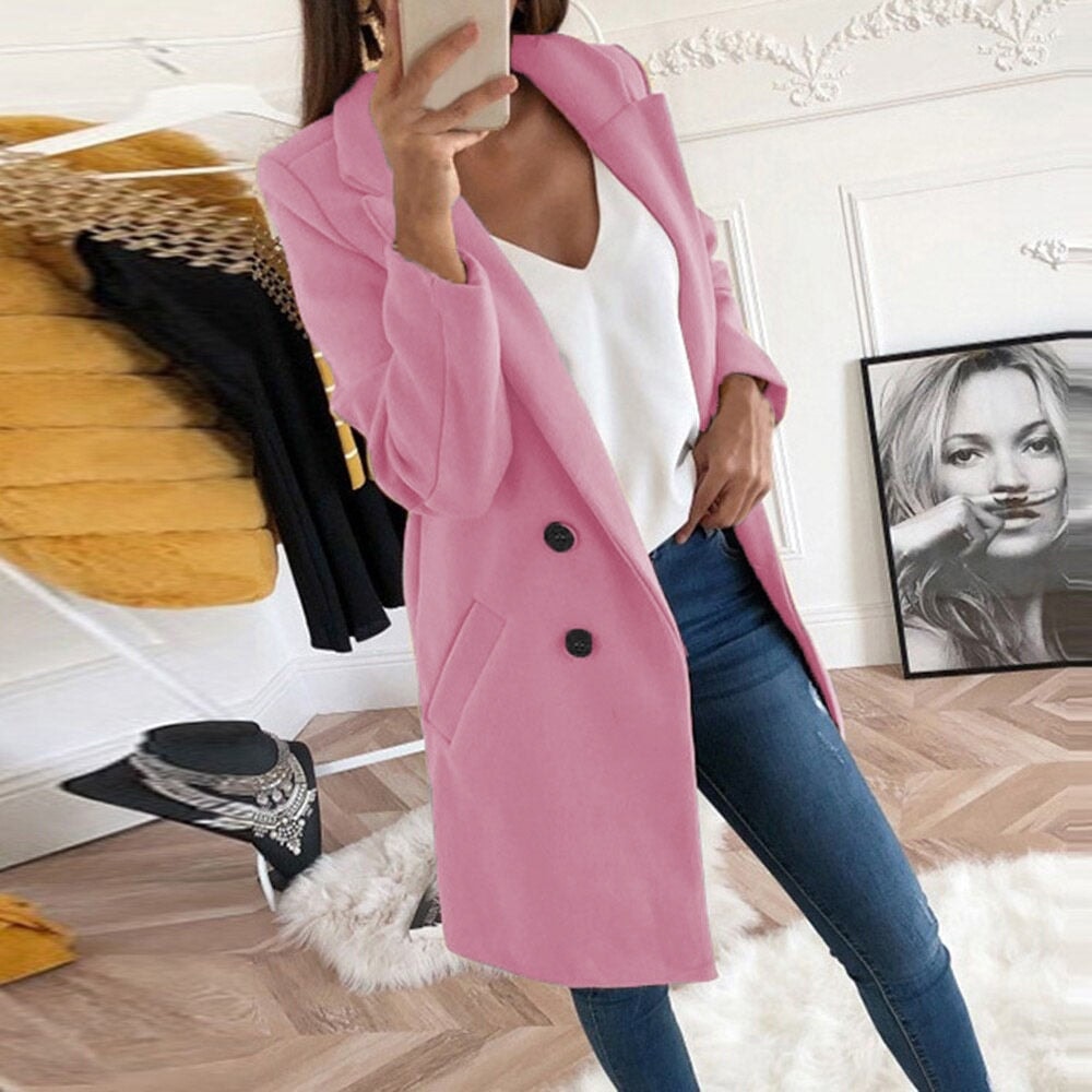 Pink mid-thigh coat with long sleeves, notch lapels, two dark buttons, and angled hip pockets styled over casual clothing.