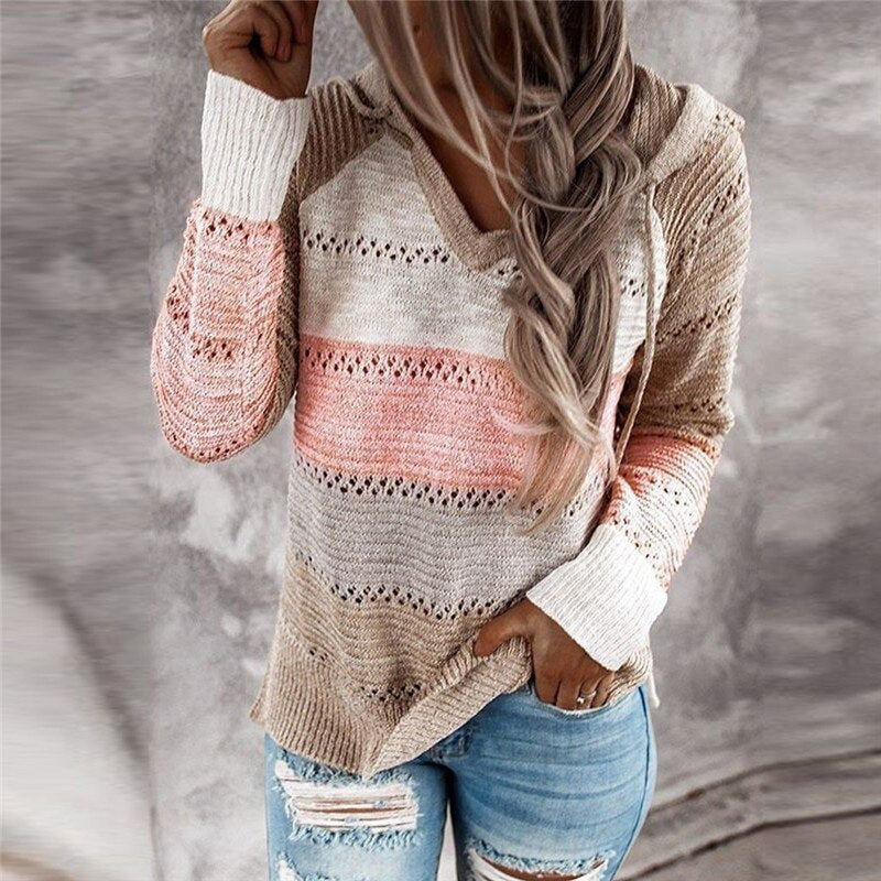 Close front view of the beige, pink, cream, and gray striped sweater, highlighting its V-neckline, openwork bands, and hood.