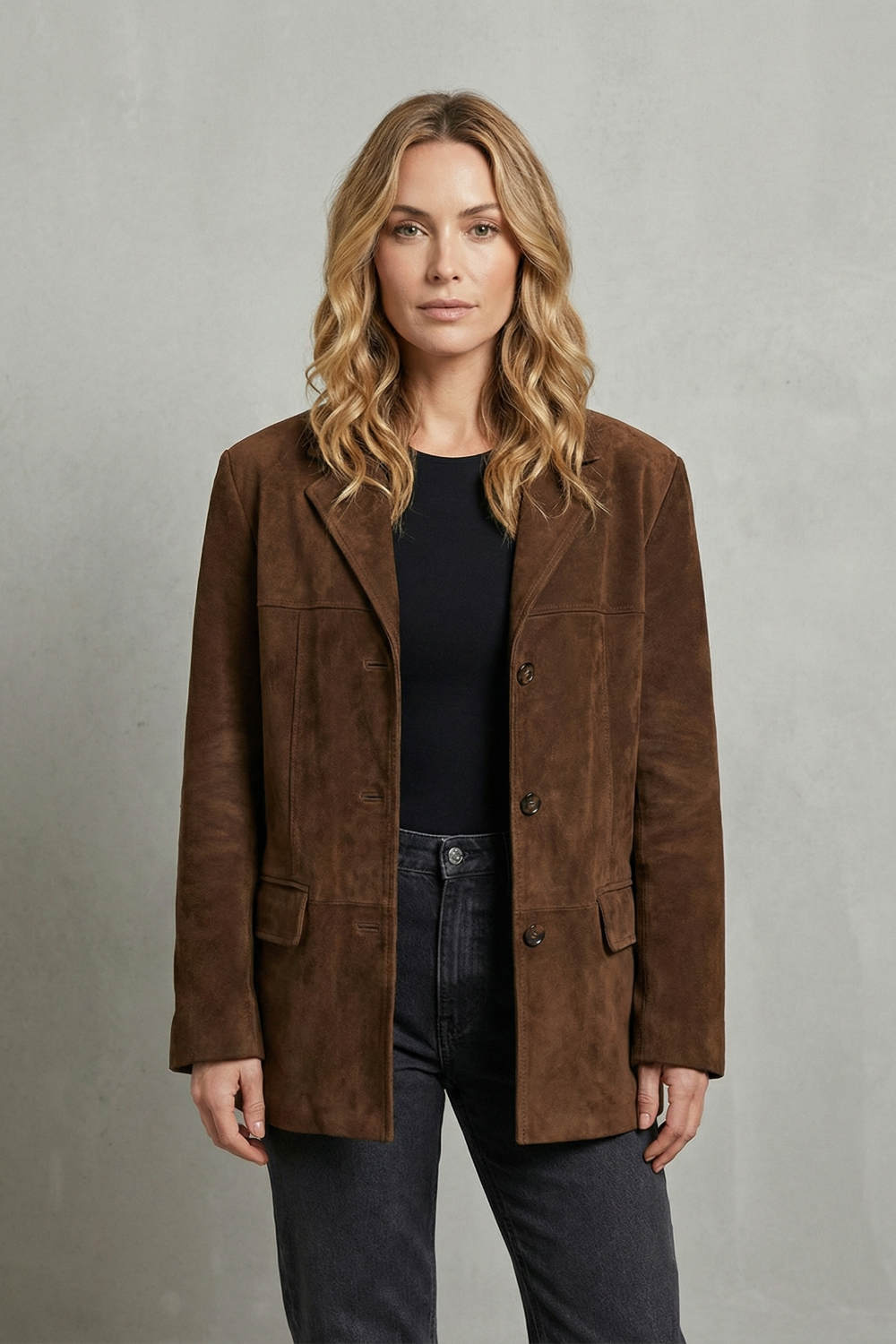 Full front view of the brown longline blazer showing its defined shoulders, tailored shape, button front, and paired flap pockets.