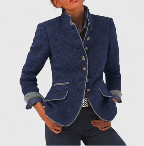 Navy tailored cardigan jacket worn with rolled cuffs, a structured stand collar, contrast trim, front buttons, and flap pockets.