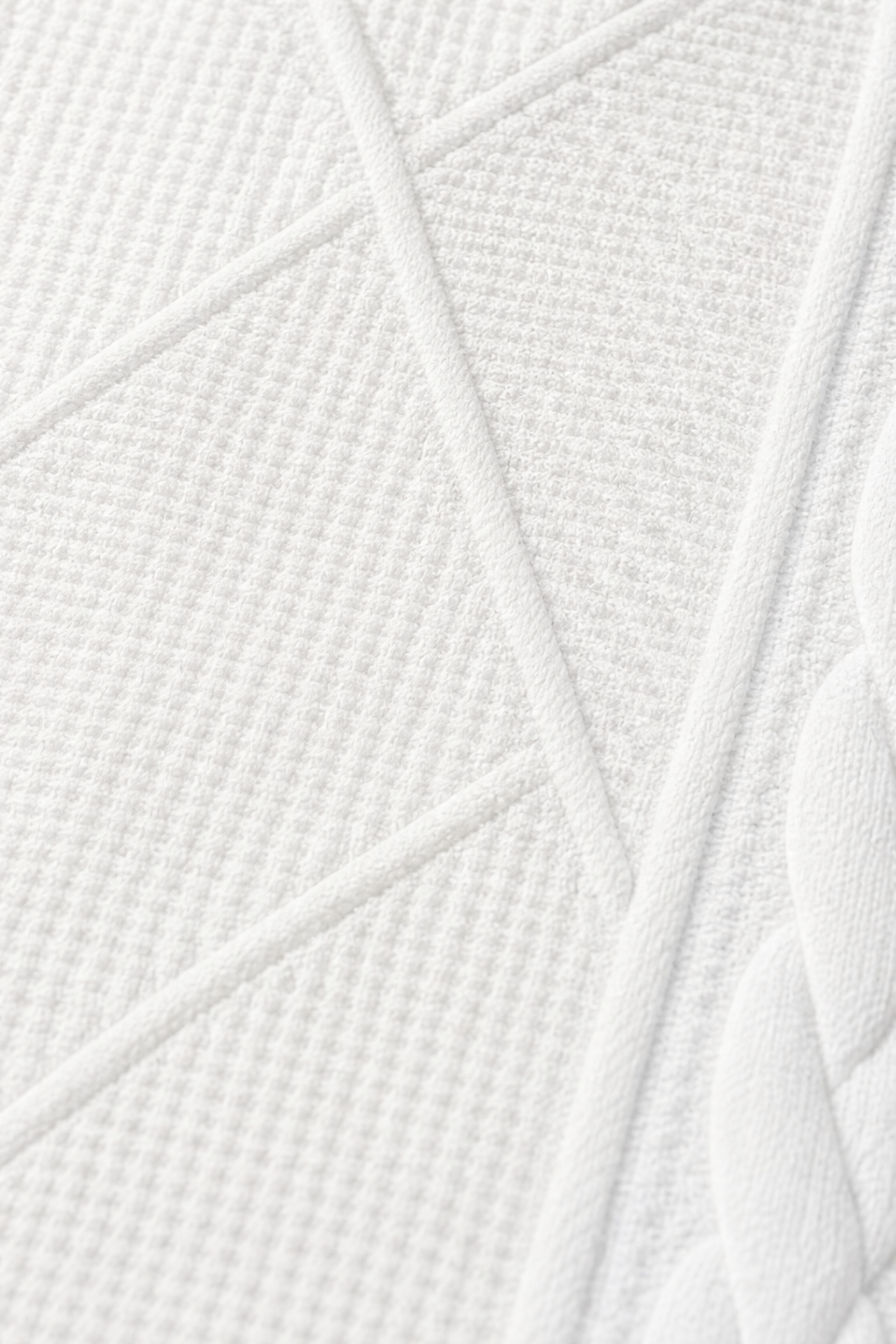 Macro view of the blazer’s geometric textured paneling and raised seam detailing.