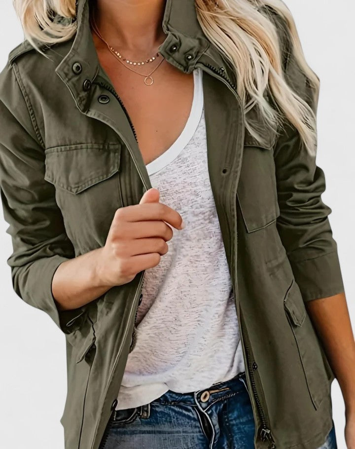 Close front view of an olive utility jacket worn open, highlighting the snap collar, flap chest pockets, zip front, and waist drawstrings.