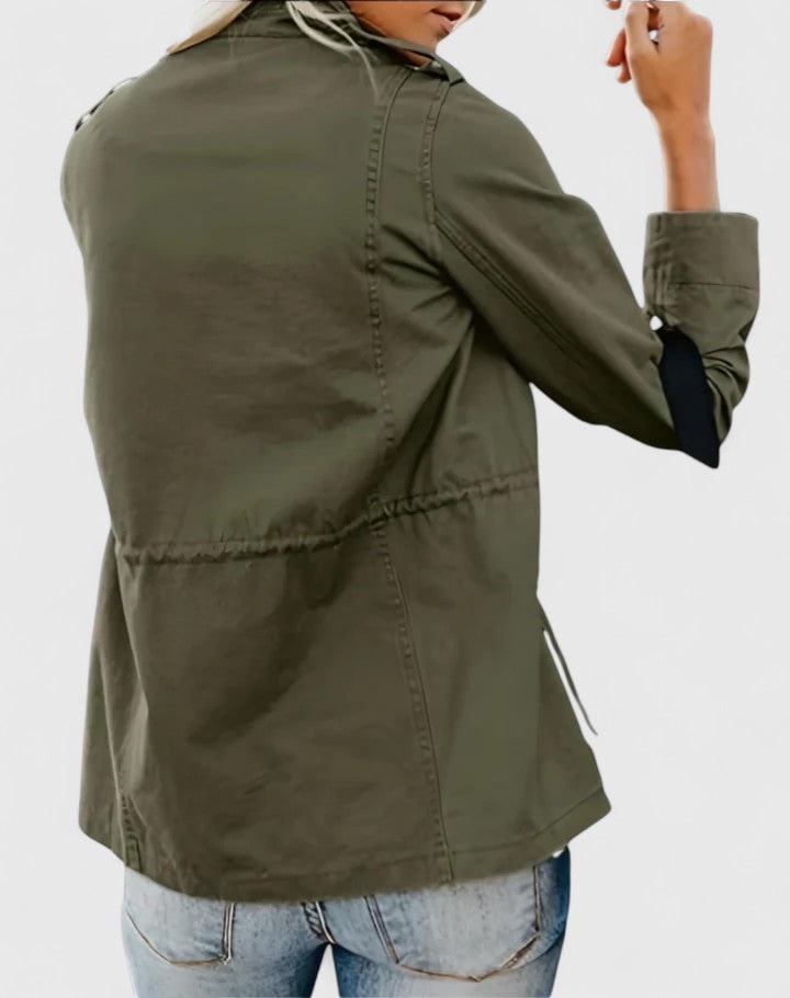 Back view of the olive utility jacket showing its hip-length cut, long sleeves, rear waist drawstring channel, and side ties.