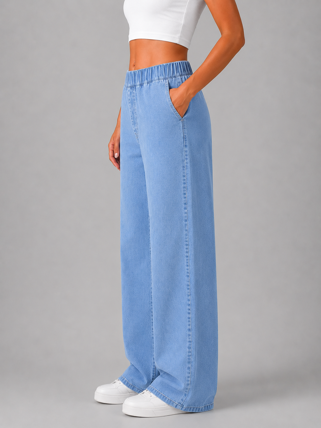 Side view of light blue wide-leg pull-on jeans showing the flowing silhouette and a side pocket.