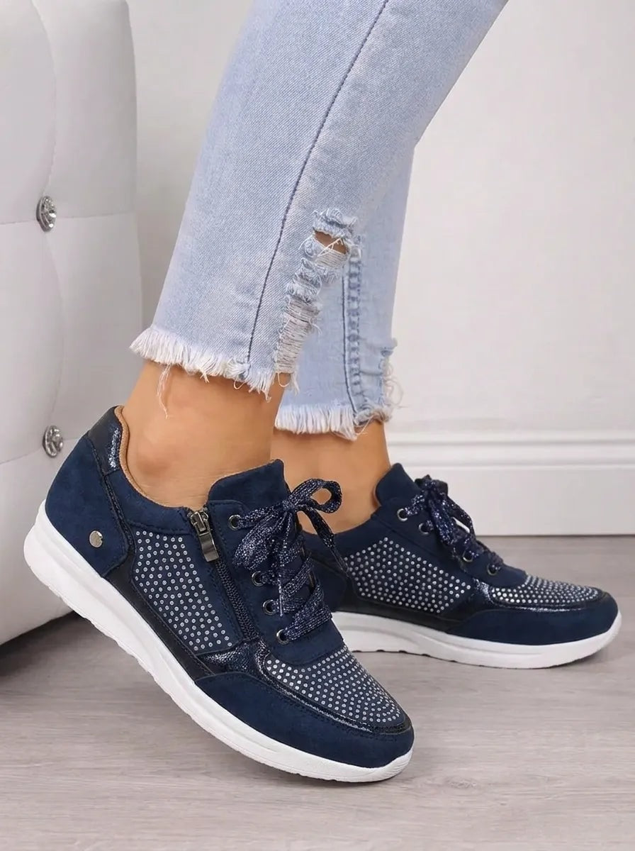 Pair of navy casual sneakers from a three-quarter side angle, with sparkling toe and side detailing visible.