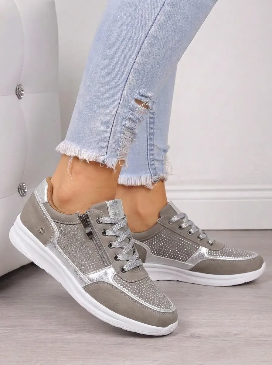 Silver-gray sneakers featuring metallic accents, sparkling toe and side panels, lace-up fronts, and white soles.