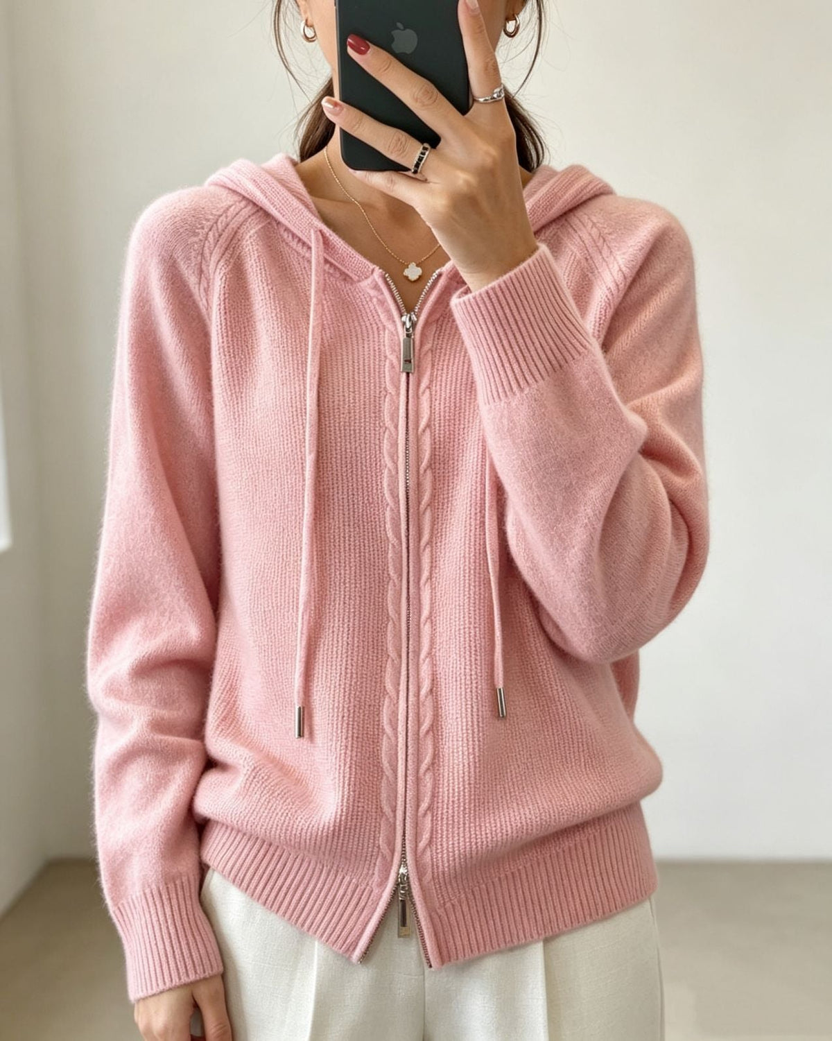 Light pink hooded cardigan featuring a full-length zipper, textured front detail, drawstrings and ribbed trim.