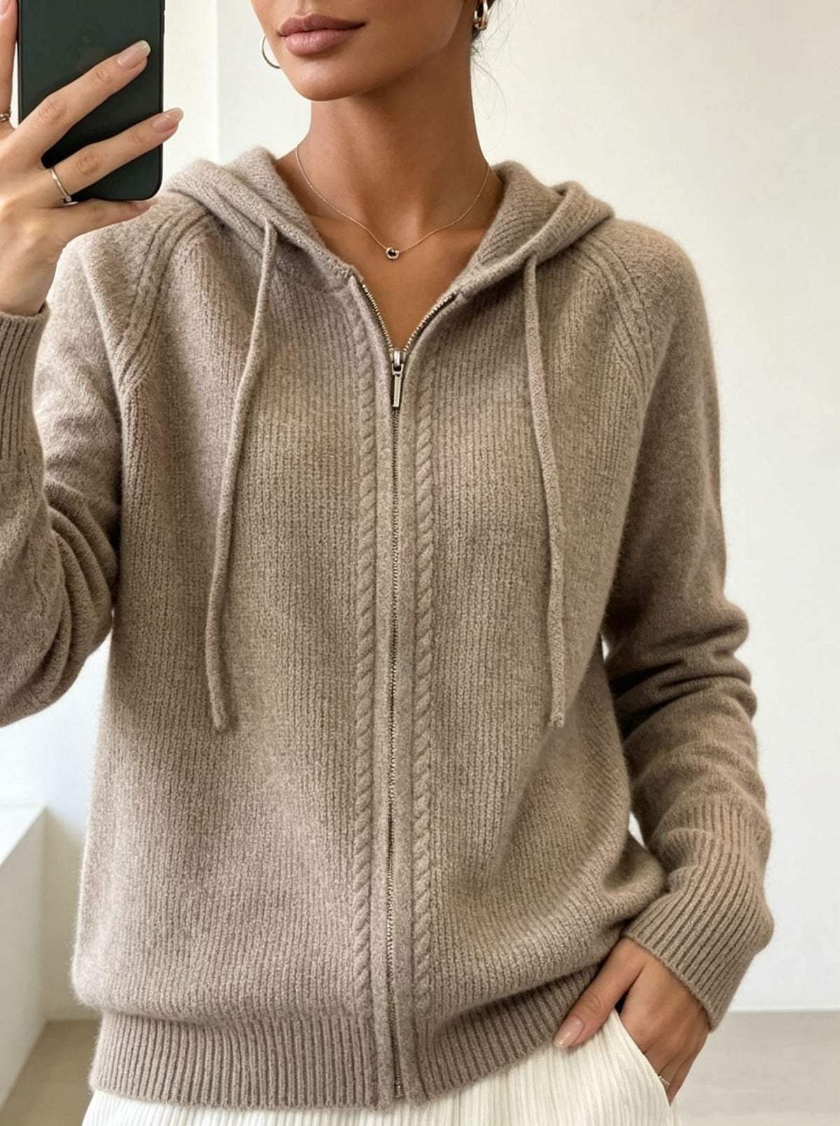 Taupe hooded cardigan with a centered zipper, extended drawstrings and a wide ribbed hem.