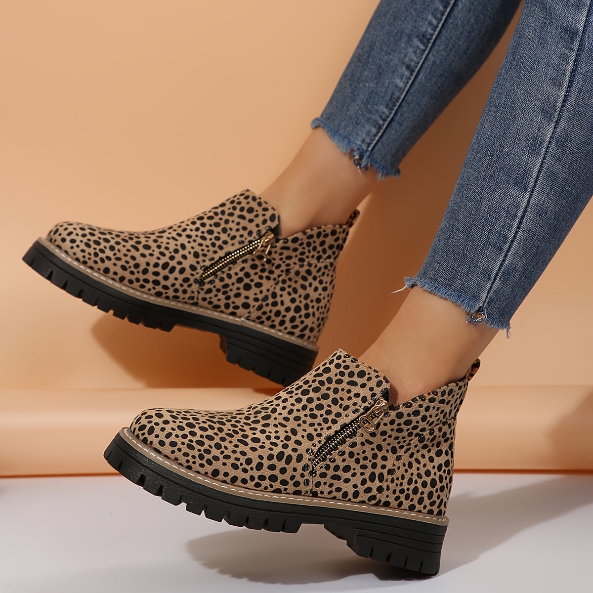 Leopard-print ankle boots in a side view, showing the side zips and low block heels.