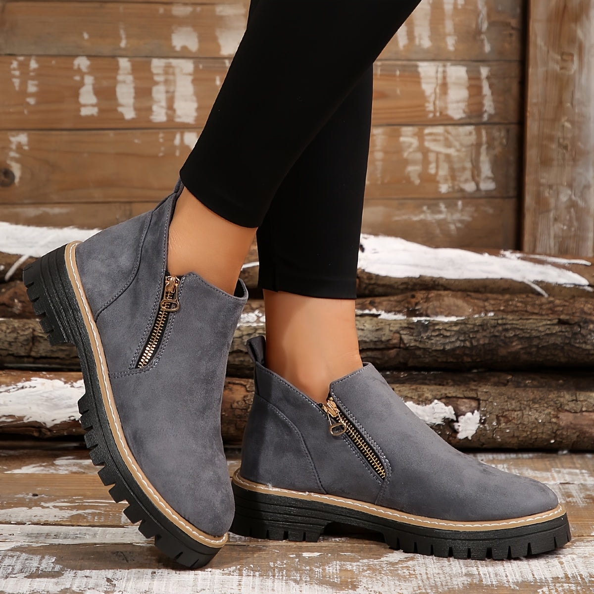 Gray ankle boots worn with black leggings, showing their side zips, low heels, and substantial soles.