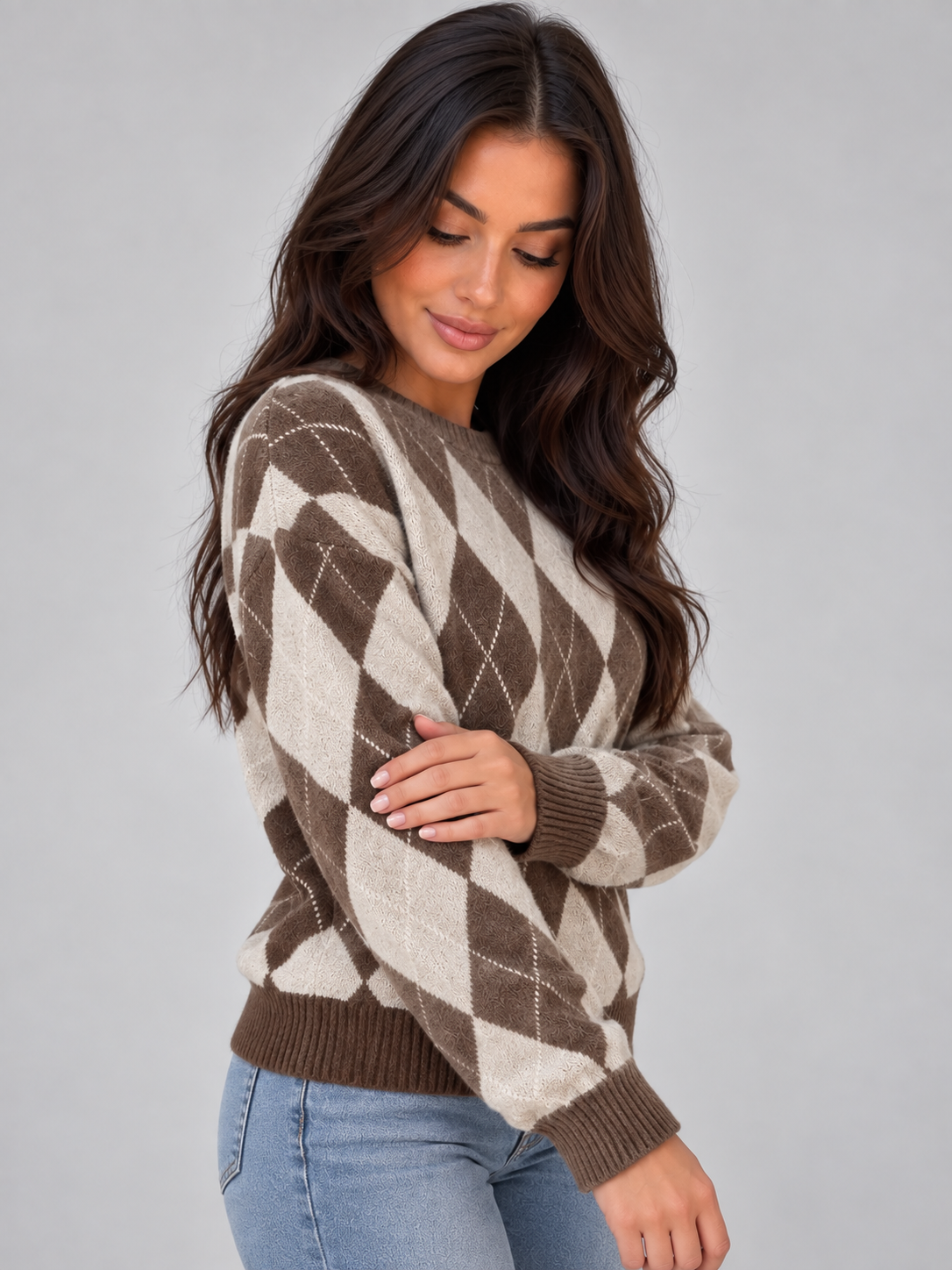 Side view highlighting the jumper’s relaxed shape, long sleeve, ribbed cuff and brown and cream argyle design.