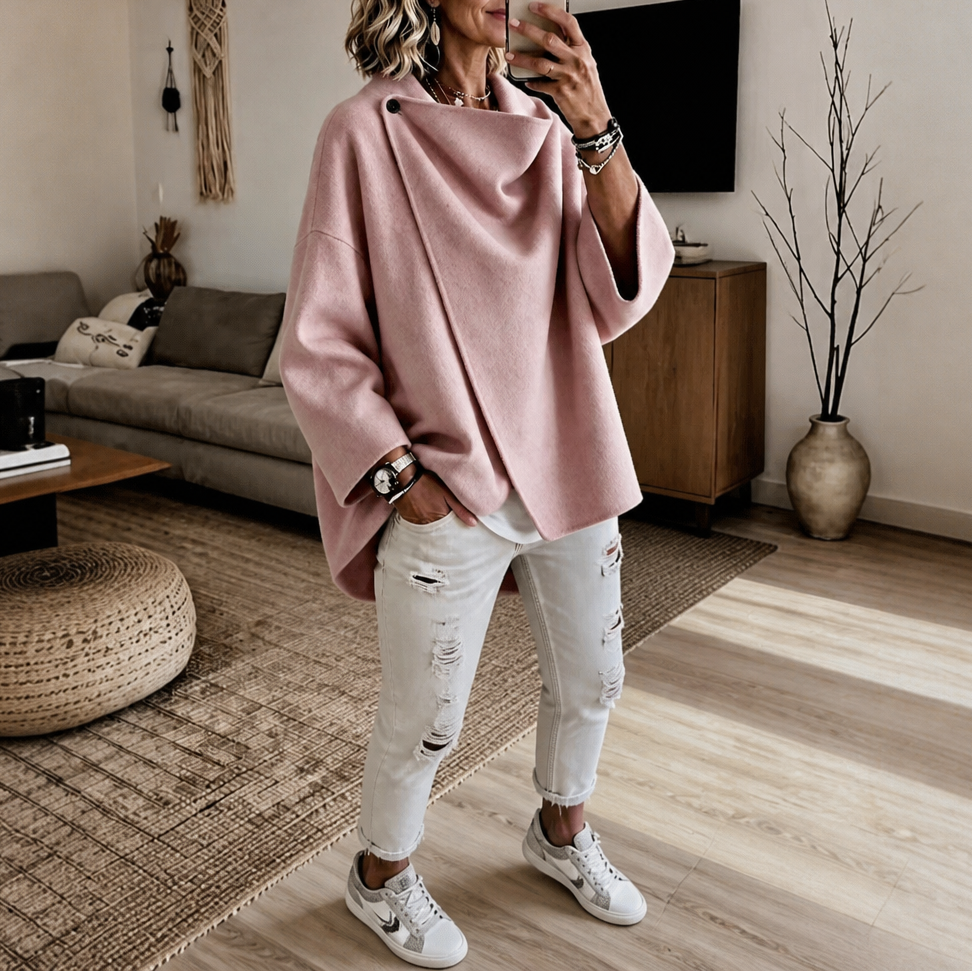 Dusty pink version of the asymmetric wrap cape jacket worn with white distressed jeans and sneakers.