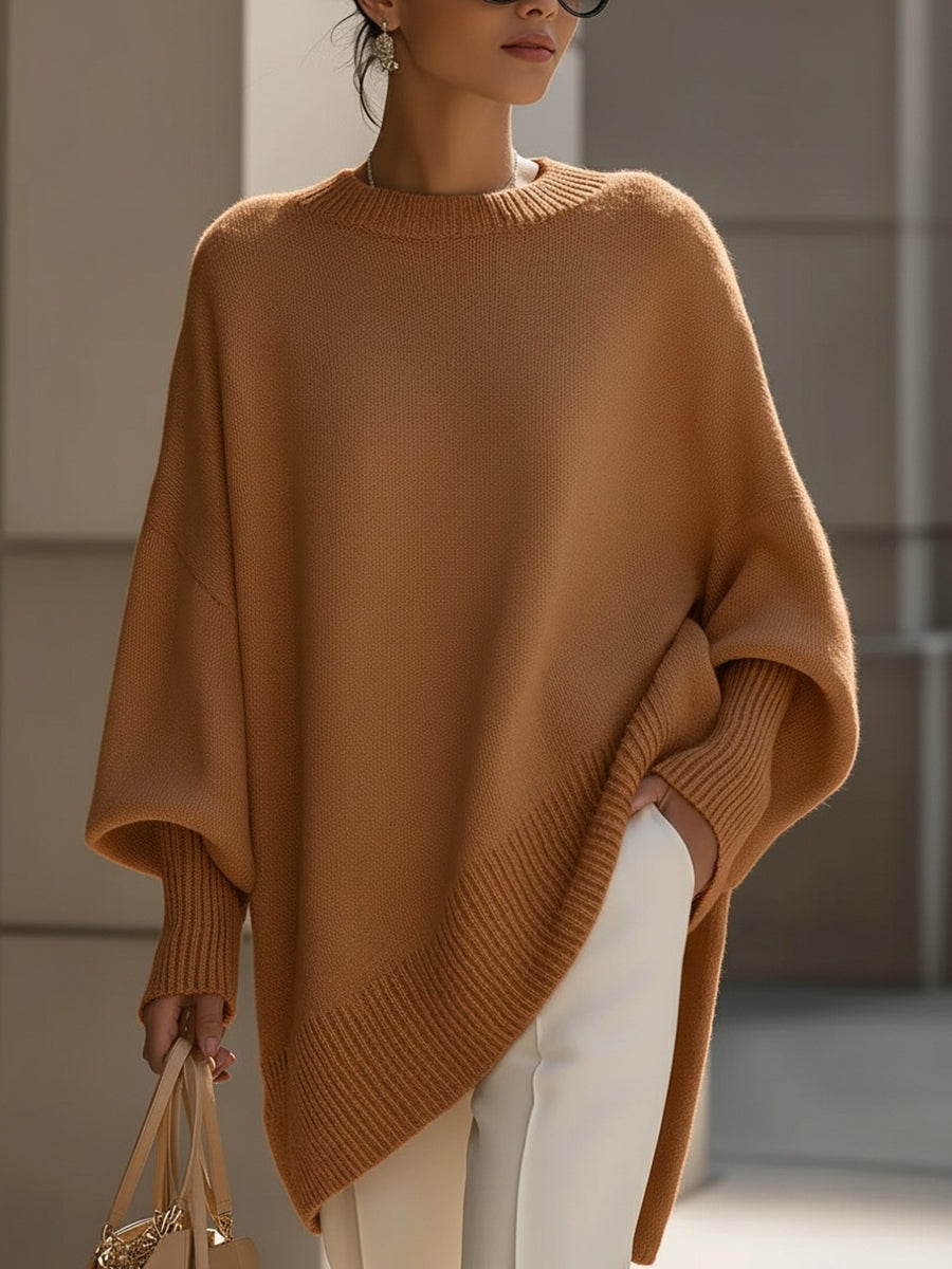 Warm brown asymmetric poncho sweater with a long pointed hem, wide sleeves, and ribbed trim.