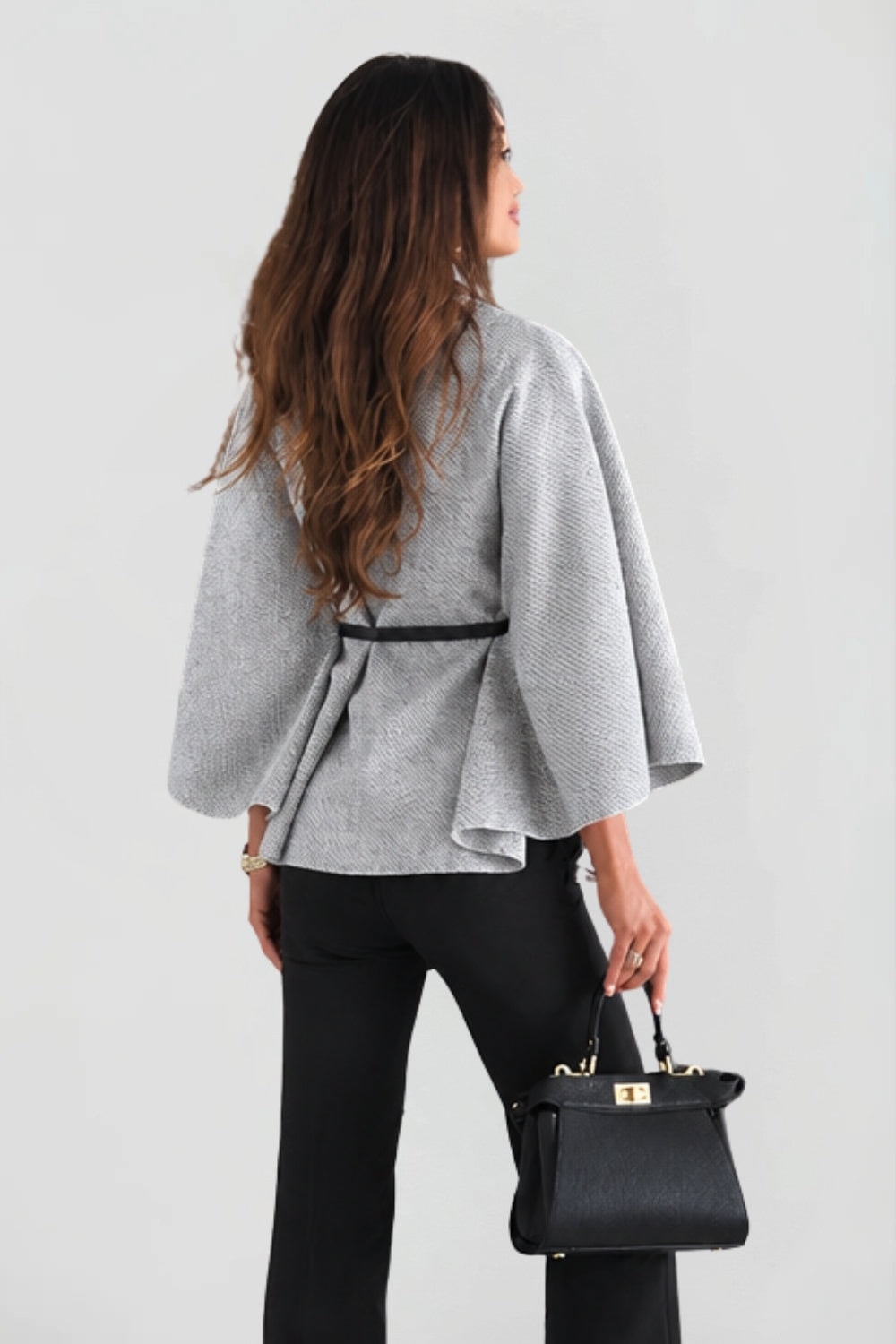 Back view of the light gray belted cape jacket, showing the defined waist and flared cape silhouette.