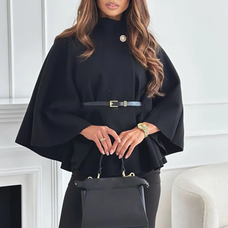Black belted cape top with a high neck, wide sleeves, and a decorative button at the neckline.
