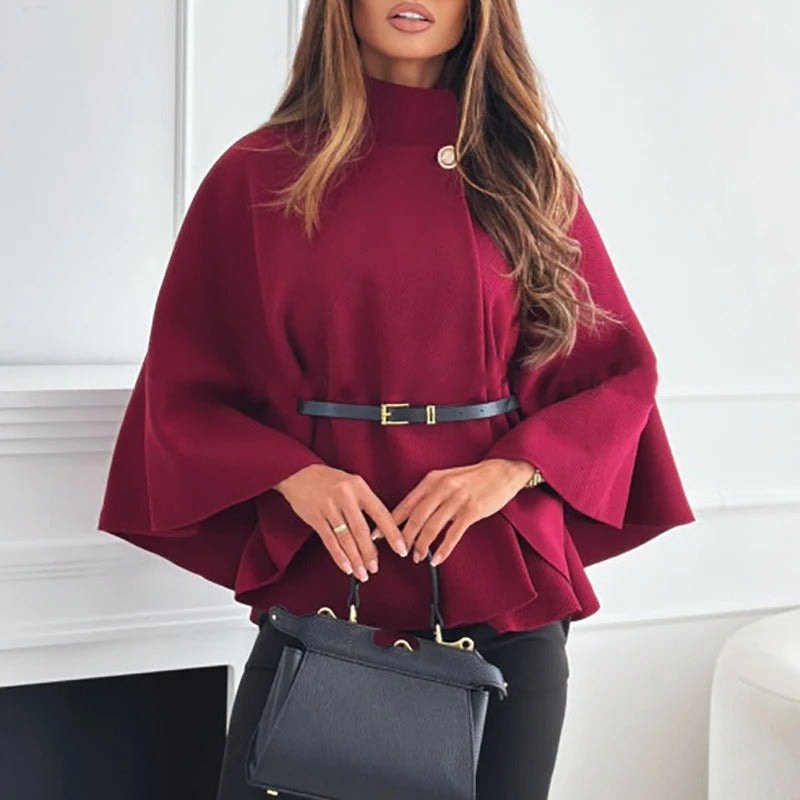 Deep burgundy cape top featuring a high neck, slim belt, wide sleeves, and a softly flared lower edge.