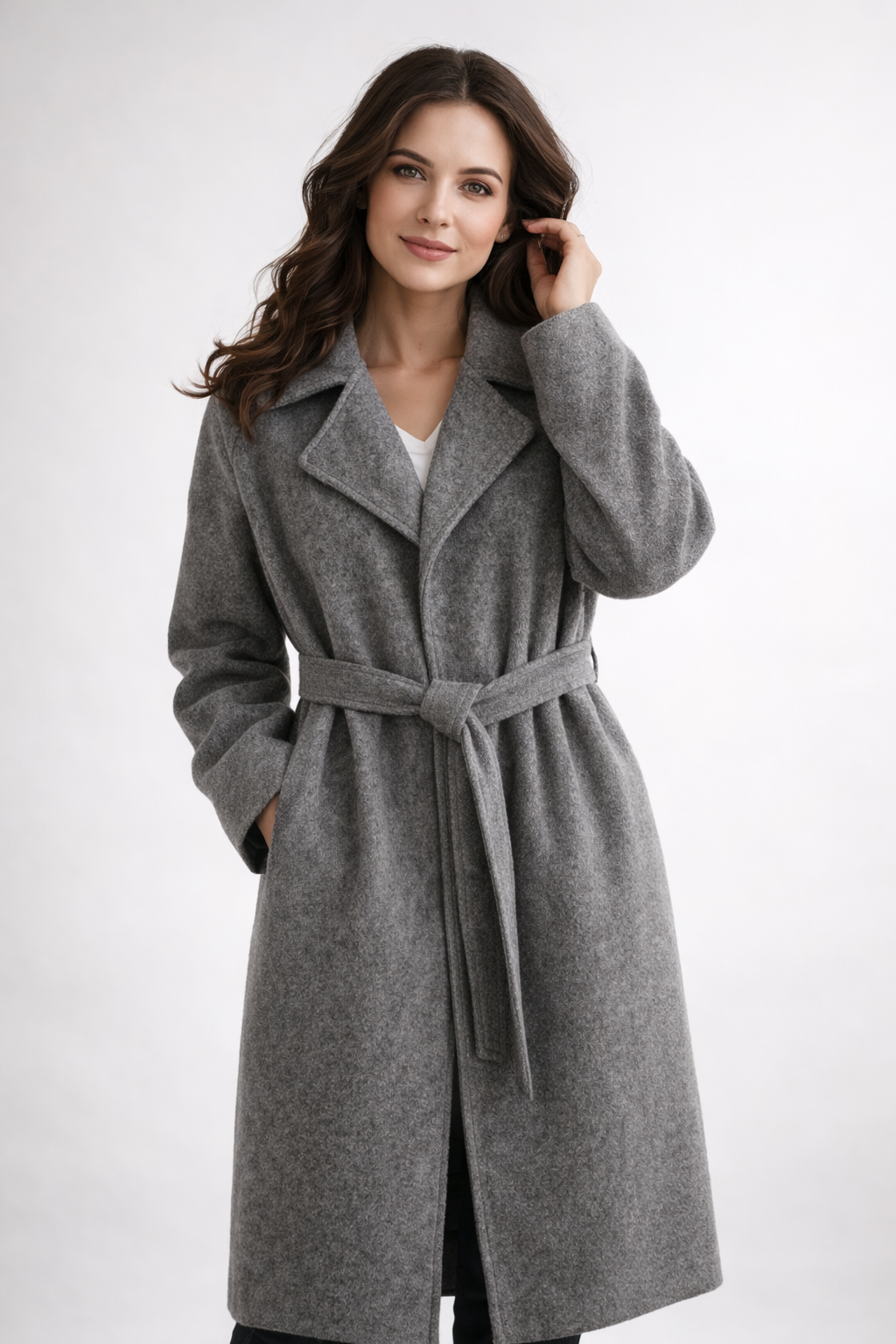 Model in a gray belted wrap coat with wide lapels, long sleeves, and a front opening below the waist.